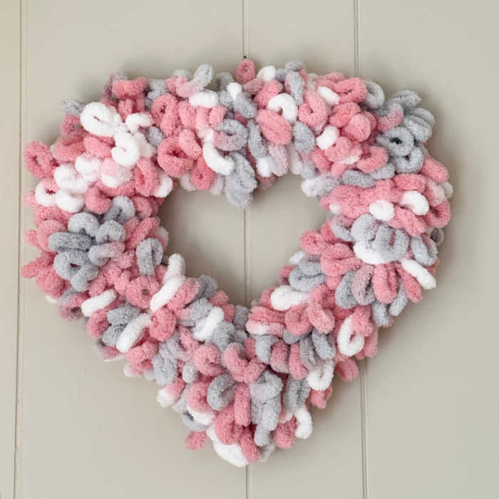 diy yarn valentine heart wreath hanging on wall