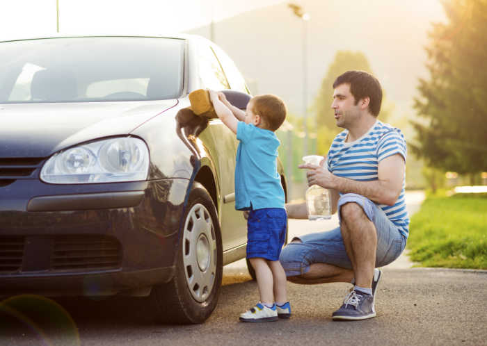 son helping dad wash car - a way to help teach empathy by helping others