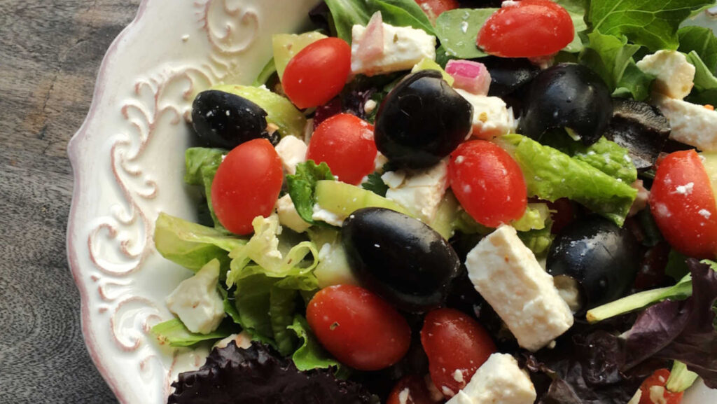 Hearty Greek Salad recipe in cream colored bowl