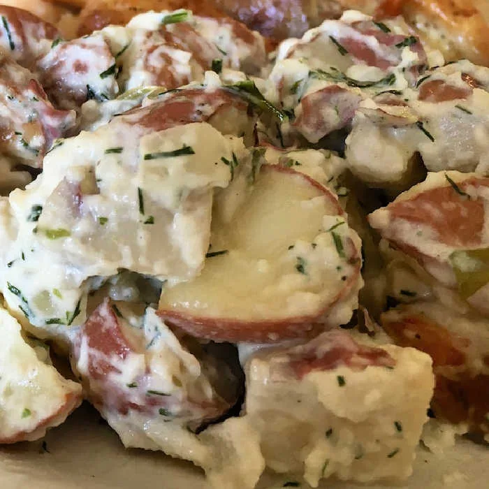 This red potato salad combines tender, fork-tender potatoes with a creamy, tangy dressing and fresh herbs for a flavorful, make-ahead side dish.